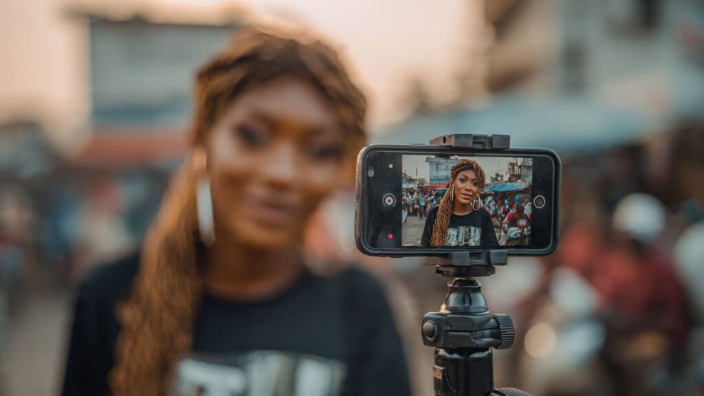 Nigerian content creator filming Instagram Reel with hook text overlay on phone