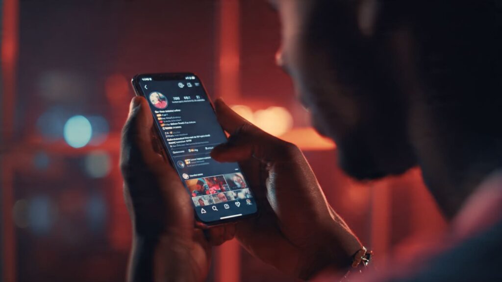 Nigerian creator checking phone showing rapidly increasing followers and engagement metrics after using strategic SMM boosting to build trust and visibility fast in Nigeria